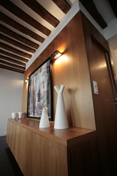 Dans la pièce à vivre, le buffet est intégré à la double paroi en placage de bois de Bete qui recouvre les murs et les portes et enveloppe l’espace de sa chaleur naturelle.