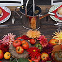 Élégante association de dahlias et tomates composant un décor de table original sur la grande table d'hôtes du Bar à Tomates de la Bourdaisière.