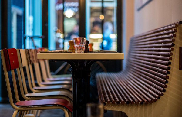 Chaises en Formica vichy et banquettes en lattes de bois pour accentuer l'esprit nostalgique des sixties.