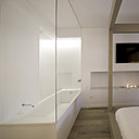 La chambre est largement ouverte sur la salle de bains, uniquement séparés par une cloison de verre clair.