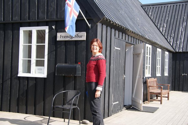Christine TrÍscote Chochoy arborant un magnifique tricot islandais devant une maison typique.