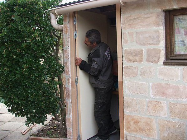 Etape 22: placer la porte sur ses branches mâles de paumelles positionnées sur le bâti, puis faire légèrement pivoter la porte par des mouvements de va-et-vient , au besoin huiler légèrement les paumelles.