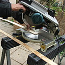 Etape 28: l’habillage du pourtour du bâti et de la maçonnerie se fera par des baguettes de bois type sapin, qui seront coupées et assemblées à coupe d’onglet.