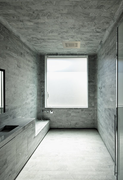 Appartement de la Muette: salle de bains en pierre bleue de Savoie dans laquelle toute la technologie, telle que le ciel de douche ou les speakers audio sont intégrés.