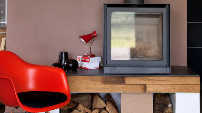 Le poêle à bois, positionné dans un espace central, redistribue la chaleur grâce à un système de ventilation double flux.