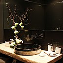 Vasques en pierre noire dans les salles de bains sur plan de travail en bois flotté traité avec un vernis mat.