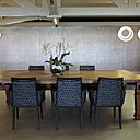 Autour de la table d’hôtes de la salle à manger principale, une série de fauteuil bridge Moda recouverts de tissu Pierre Frey.