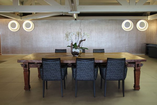 Autour de la table d’hôtes de la salle à manger principale, une série de fauteuil bridge Moda recouverts de tissu Pierre Frey.