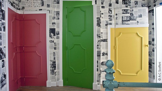 Au 1er niveau, trompe-l’œil de portes moulurées et peintes redimensionnées qui contrastent avec des murs tapissés d’archives, aux teintes plus neutres, de Paris Match. Au 1er niveau, trompe-l’œil de portes moulurées et peintes redimensionnées qui contrastent avec des murs tapissés d’archives, aux teintes plus neutres, de Paris Match.