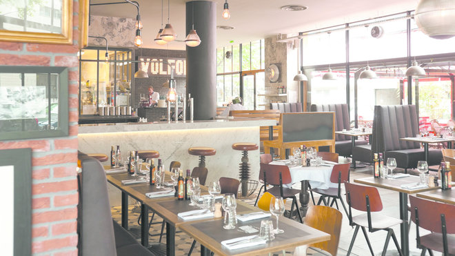 La grande salle lumineuse, son bar et au fond son comptoir à pizzas. La grande salle lumineuse, son bar et au fond son comptoir à pizzas.