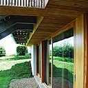 A l’extérieur, menuiseries et bardage sont en douglas naturel. Une grande pelouse souligne le rapport étroit que la construction entretient avec le sol naturel. Elle s’inscrit dans la logique du minimalisme qui caractérise de façon générale le projet.