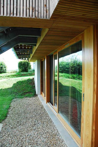 A l’extérieur, menuiseries et bardage sont en douglas naturel. Une grande pelouse souligne le rapport étroit que la construction entretient avec le sol naturel. Elle s’inscrit dans la logique du minimalisme qui caractérise de façon générale le projet.