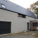 Mur pignon en monomur de brique enduite et  cabane de jardin.