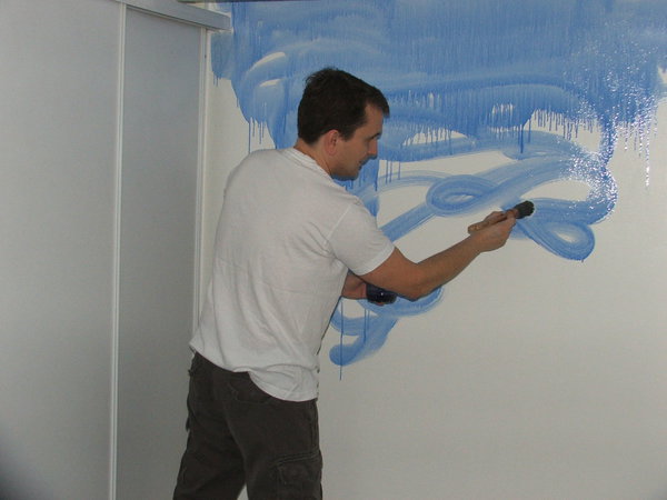 Etape 2 : Commencer par badigeonner le mur à la brosse de pouce, en tous sens et de façon irrégulière, en commençant par le haut et en allant vers le bas. Le glacis étant très fluide, il est important de travailler assez rapidement sans trop appuyer sur l’outil, afin d’éviter de grosses coulures, et surtout de ne pas trop éclabousser. Travailler pan de mur par pan de mur.