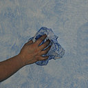 Etape 7 : Le chiffon pris à pleine main et imbibé de glacis teinté il devient plus souple,  passer en tapotant à quelques endroits un peu trop enlevés faisant apparaitre la couche de fond blanche. Cela aura pour but de nuancer les contrastes de teintes, entre le bleu du glacis et le blanc de la couche de fond.