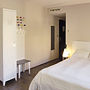 28 chambres avec un parquet en chêne et une vue panoramique sur la ville de Lyon ou le chemin de l’Ermitage. Armoire en tôle blanche Tolix et porte-manteau Vitra.