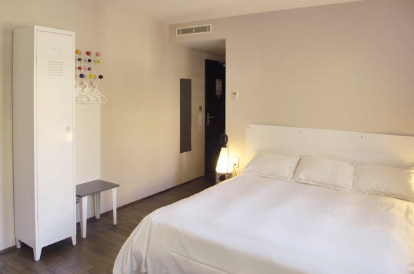 28 chambres avec un parquet en chêne et une vue panoramique sur la ville de Lyon ou le chemin de l’Ermitage. Armoire en tôle blanche Tolix et porte-manteau Vitra.