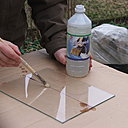 Etape 4 : Retourner la feuille de verre. Le tracé devra être en dessous. Puis, à l’aide d’un pinceau, passer un filet de white-spirit sur la ligne représentant la coupe ; cela servira  au coupe-verre d’être lubrifié et ainsi d’avoir une bonne glisse continue sur la feuille de verre.