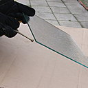 Variante 3 : Détonner le verre avec la boule du coupe-verre, tout le long de la rayure de coupe. Placer l’outil sous la feuille de verre. Ne surtout pas trop taper.