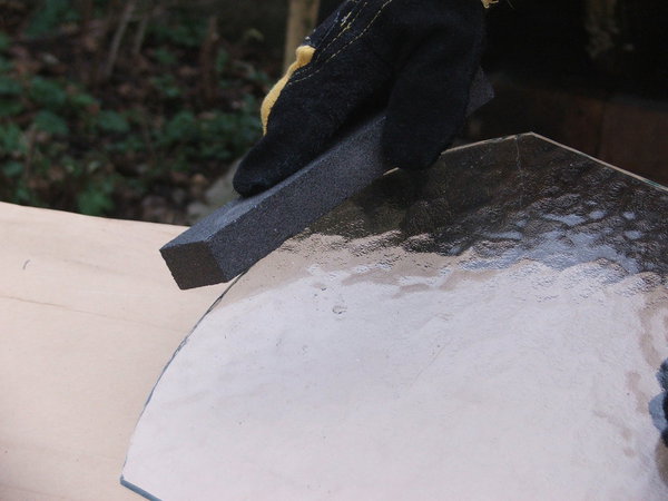 Variante 6 : Passer la pierre de carborundum légèrement mouillée sur la coupe des deux côtés de la feuille de verre, en poussant le geste d’un seul trait et à plusieurs reprises.