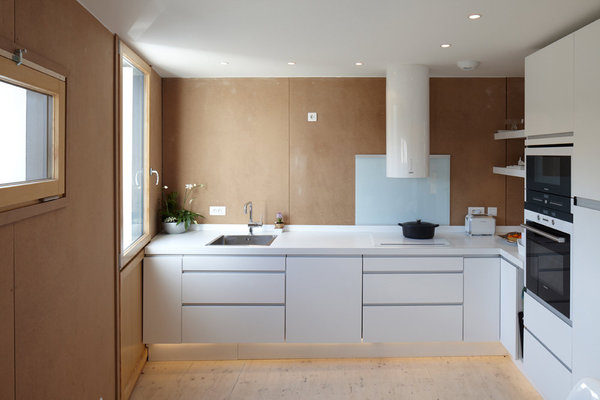 La cuisine conjugue rangements en laqué blanc, et murs en médium brut.