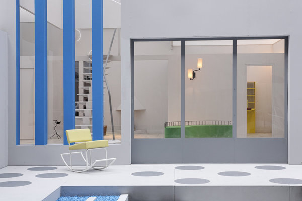 Le vaste salon et son canapé haricot, les baies vitrées et les fauteuils coquetiers du couple... On croirait entendre Madame Arpel : " C'est si pratique. Tout communique ! ".