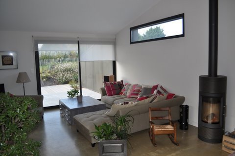 Le salon en angle compose un coin cosy toujours ouvert sur l’extérieur.