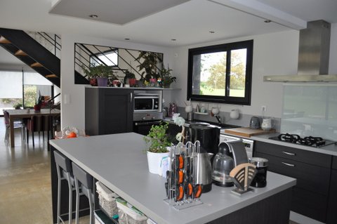 La cuisine, semi-ouverte, est à la fois confidentielle et conviviale, en fonction du moment de la journée. Occultée par un mur, quand elle n’est pas utilisée, elle offre un accès facile.