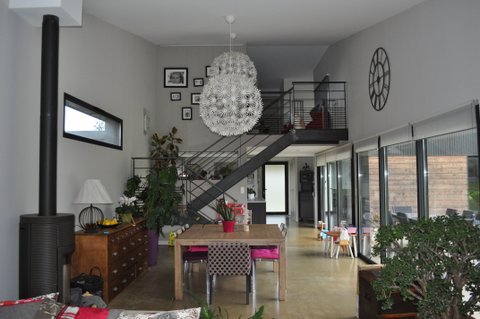 L’espace du premier niveau est doté d’une façade entièrement vitrée et de meuble qui font office de séparation de pièces.