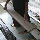 Etape 8 : Les lames qui iront contre le mur seront retaillées au niveau des languettes en les supprimant. Pour cela, les couper soit à la scie sauteuse, soit pour plus de précision à l’aide d’une scie circulaire sur banc.