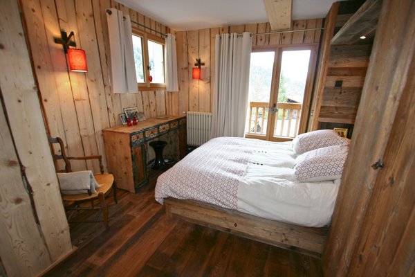 Les matières colorées associées au vieux bois des pays de l’Est font de cette chambre un espace cosy. Commode Caravane et lampes Angel des Montagnes.