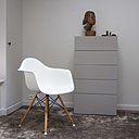 Un fauteuil culte design de 1950, modèle Eames Plastic Arm Chair de Ray & Charles Eames, modernise la chambre repeinte en gris.