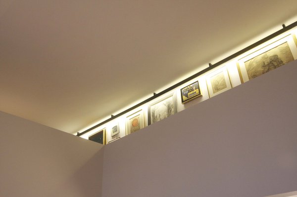 Sur la mezzanine, les tableaux sont désormais alignés de façon graphique et mis en valeur par un éclairage adapté.