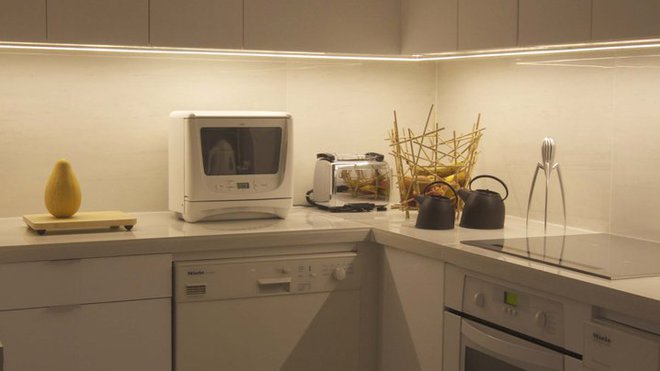 Le sol de la cuisine (rangements Ikea) est recouvert de grès cérame. Le plan de travail et la crédence imitent les effets d’un marbre veiné gris.