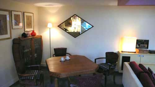 Avant, une salle à manger avec des meubles des années 1940-50 et une ambiance rétro-vintage sur fond de couleurs rose et jaune.