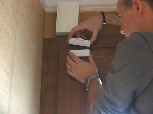 Etape 7 : placez le détecteur d’ouverture à l’intérieur de l’habitation sur le montant de la partie ouvrante, soit horizontalement, soit verticalement (à l’opposé des gonds). Marquez les endroits à percer. Utilisez une ou plusieurs cales d’épaisseur fournies pour que de détecteur et le porte-aimant soient parfaitement au même niveau.