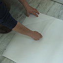 Etape 3 : Tout en tirant la pellicule, au dos du sticker, maintenue en coin à la main, ôter la pellicule d’un geste régulier et perpendiculaire au support.