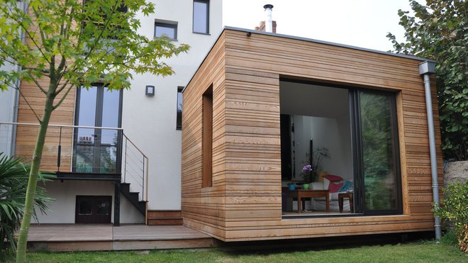 L’extension posée sur la terrasse en ipé, sans lien avec la pelouse, semble flotter au-dessus du jardin. L’extension posée sur la terrasse en ipé, sans lien avec la pelouse, semble flotter au-dessus du jardin.