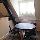 Le coin repas jouxte la cuisine, qui joue la carte de la discrétion derrière un muret.