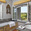 La salle de bains de la suite Bérangère d’Alamanon : des tons bleu et jaune pour un style provençal, ainsi qu’une vue magnifique sur les jardins et les vignes du domaine.