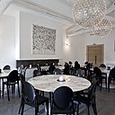 Les grandes tables ovales en marbre Saarinen apportent finesse et volupté à cette salle de réunion. Cette légèreté contraste avec les chaises noires opaque dessinées par Philippe Starck pour Kartell, ainsi que la grande cheminée contemporaine toute linéaire.