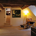 Le salon épuré donne également accès à la chambre, nichée sous les toits.