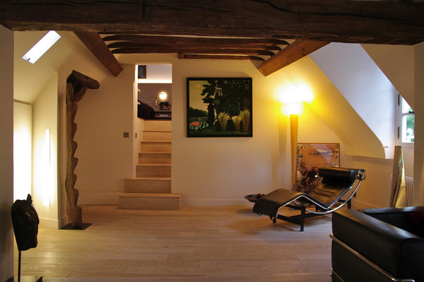 Le salon épuré donne également accès à la chambre, nichée sous les toits.