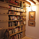 Comme un prolongement du salon, glissée entre les poutres, la bibliothèque trouve astucieusement sa place dans un recoin de l’appartement.