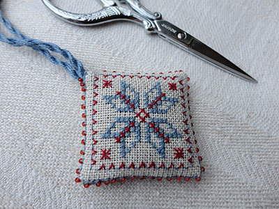 Coussinet brodé au point de croix de Schaarhangertje.