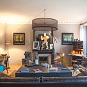 Le salon de détente n’a  conservé que sa cheminée, ses corniches au niveau du plafond et son parquet en point de Hongrie. Le canapé en cuir dessine un axe de symétrie renforcé par la présence de deux tableaux de part et d’autre de la cheminée. Comme les fauteuils, il a été sauvé de la décoration précédente et intégré à cette nouvelle ambiance.