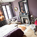 La chambre, décorée façon boudoir, dénote d’une ambiance radicalement différente, qui sied plus à la vocation cosy de la pièce. Un dégradé de tons lilas, doux et féminin, nappe l’espace.