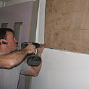 Etape 2 : Remplissage des parties en retrait par un panneau de bois. Positionnement en attente de pose (à gauche) des échelles (panneaux de bois évidés) destinées à recevoir les panneaux de verre.