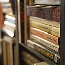 Le bar est habillé de rangements ouverts et remplis d’une collection de livres disparates, achetés par lots, très bon marché, chez Emmaüs.