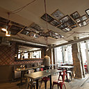 La salle de restaurant fait penser à un décor de cinéma reconstitué avec les parties basses des murs peintes et un papier peint à losanges très marquant.